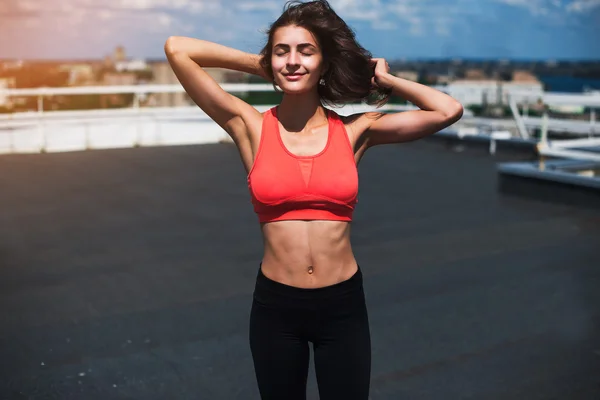 Portrait of a fitness woman doing warm up exercises outdoors