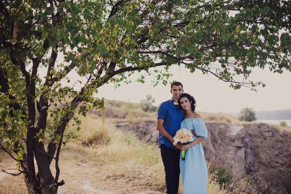 Young couple in love bride and groom, wedding day in summer. Enjoy a moment of happiness and love in a lavender field. Bride in a luxurious wedding dress. Summer mood and freedom.