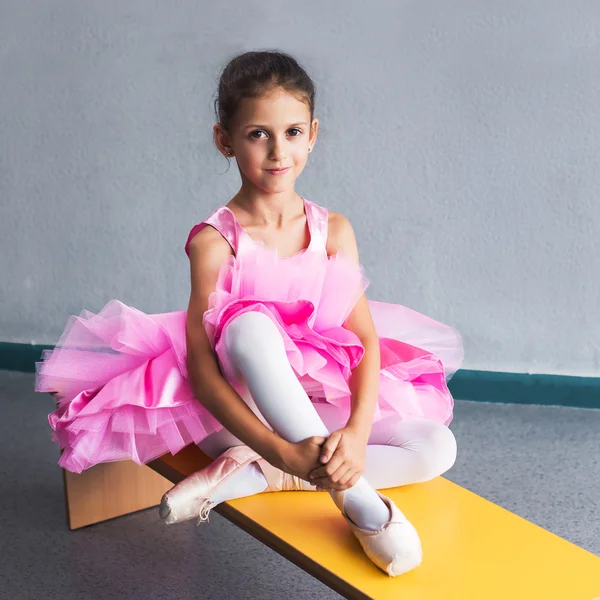 Beautiful little ballerina in pink dress in dance class