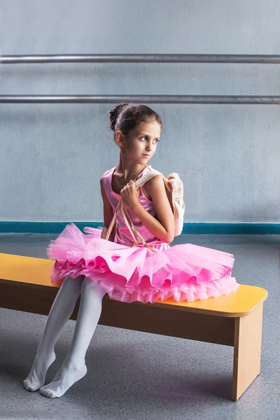 Beautiful little ballerina in pink dress in dance class