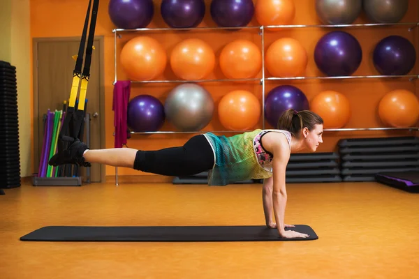 Women doing push ups training arms with trx fitness straps in the gym Concept workout healthy lifestyle sport