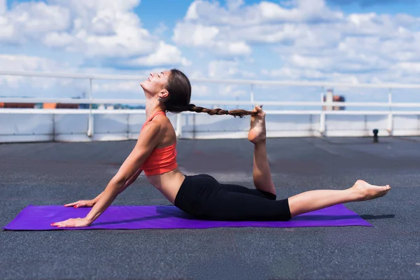 Yoga and meditation in a modern urbanistic city. Young attractive girl - yoga meditates against modern skyscrapers