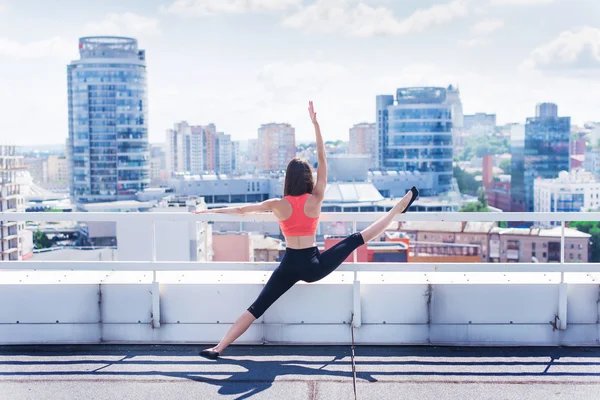 Yoga and meditation in a modern urbanistic city. Young attractive girl - yoga meditates against modern skyscrapers