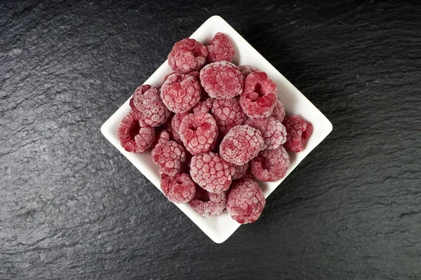 Frozen raspberries in a porcelain dish