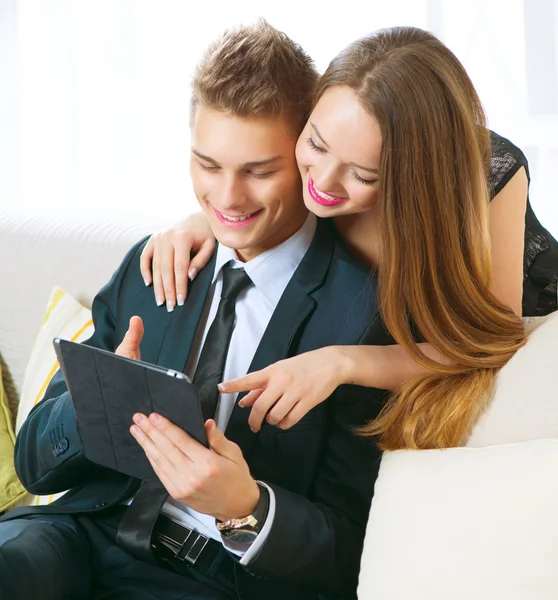 Young couple with tablet pc chatting or buying online