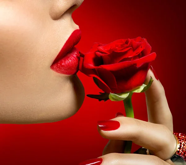 Woman kissing red rose flower.