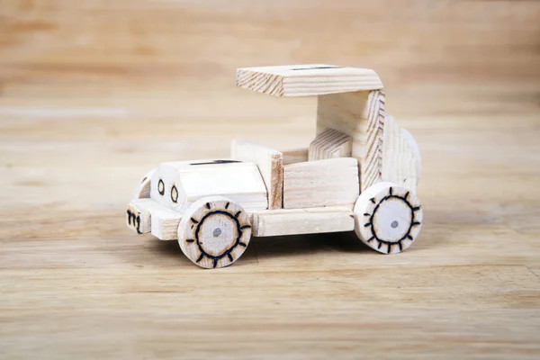 Hand-made wooden car in wood background.