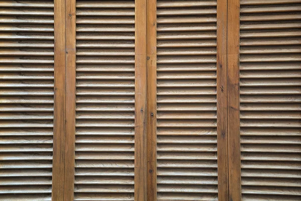 Brown, wooden, vertical completely covered blinds.