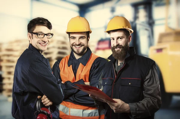 Smiling workers in front of forklift