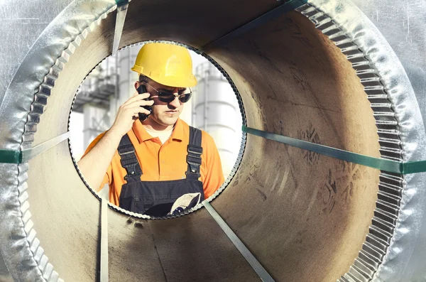 Worker seen through a steel sheet metal roll