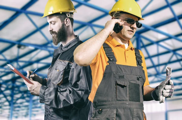 Workers in protective uniforms in production hall