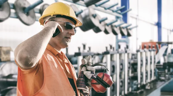 Worker with protective uniform in front of production machine