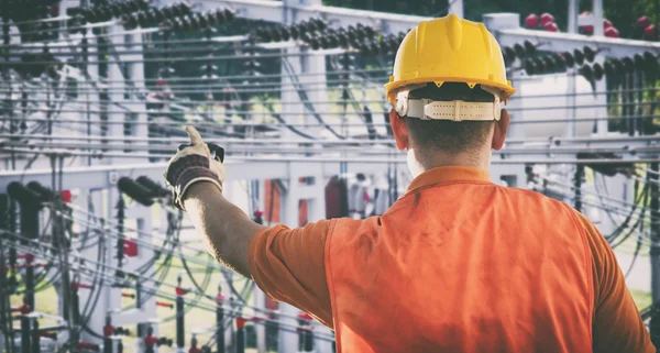 Worker with protective uniform in front of power plant