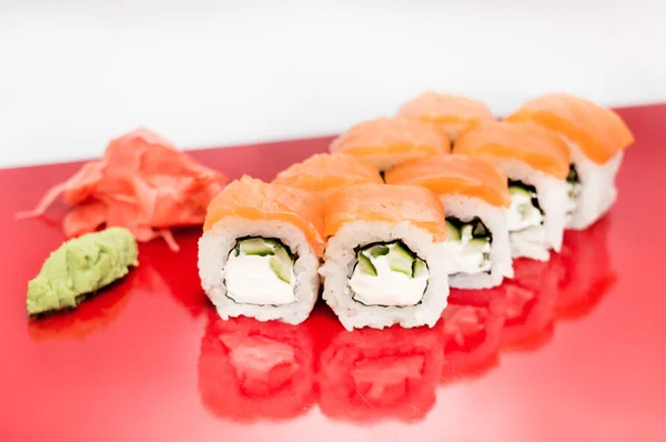 Sushi roll Philadelphia closeup on a red plate isolated