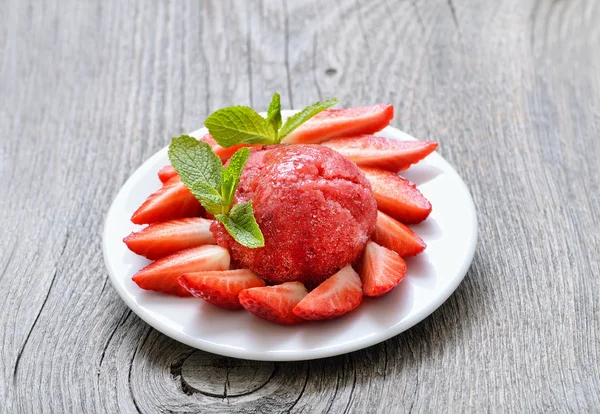 Fruit strawberry sorbet with mint in a white plate