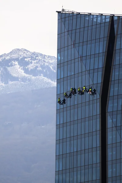 Six climbers wash windows and glass facade of the skyscraper