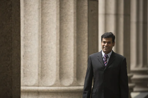 Indian businessman outside a colonial courthouse building