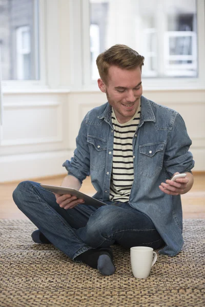 Man on floor at home and using Tablet