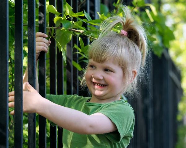 The child climbs on the fence