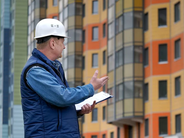 Engineer standing on the background of a new apartment building