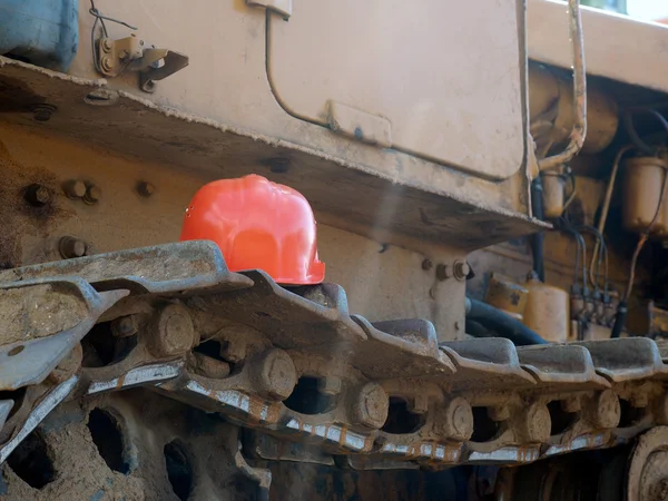 Orange construction helmet on the tractor tracks