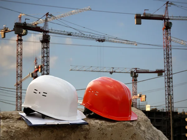 Building helmet on a background of cranes, construction