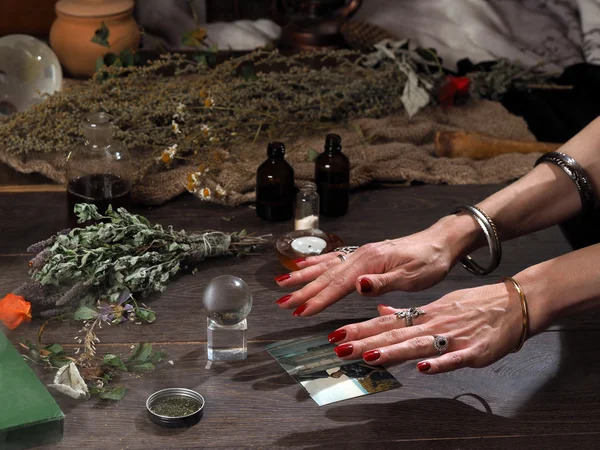 Work hereditary Sage. Find people on photos. Hands witch. working table magician. Photo missing person. The magic transparent sphere. Many medicinal herbs. Magic, psychic, occult, magic