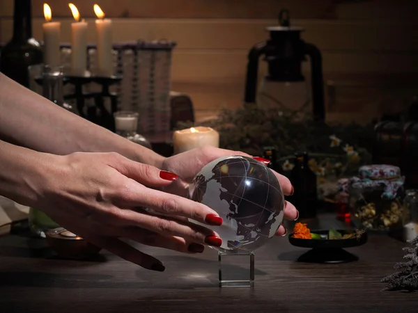 Hands witch. Transparent sphere. Magical objects and utensils of the alchemist. Candles, herbs. Concept - alternative medicine, witchcraft and the occult. Halloween. Divination, sorcery. Work Healer