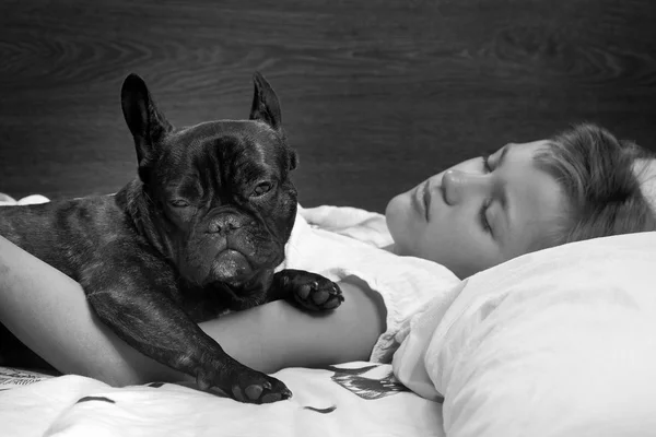 Joint dream girl and dog. Man and animal sleeping together on the bed