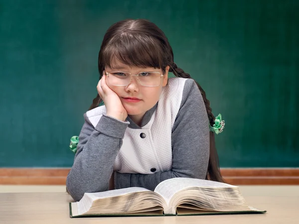 Girl in the classroom. Great tutorial, blackboard. Child obesity full. Schoolgirls boring, do not like to study. Portrait