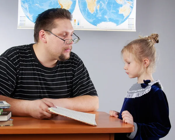 The teacher shows the child diary. Primary School