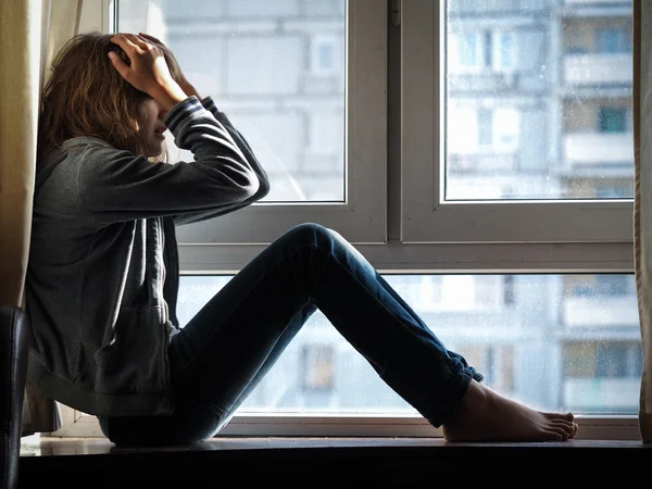 Teen Girl crying at the window