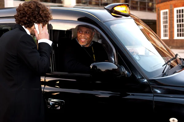 Businessman talking to taxi cab driver