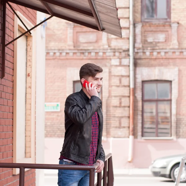 Handsome businessman in leather jacket speaking on the phone