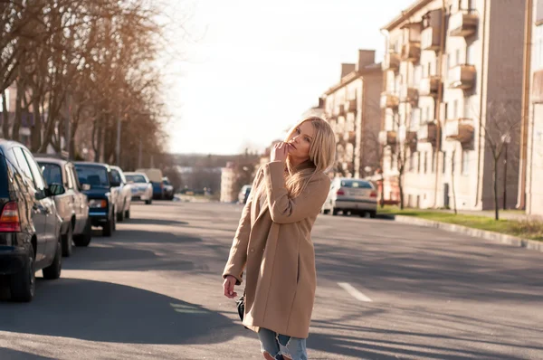 Amazing blonde girl walking alone on the road in old european city.