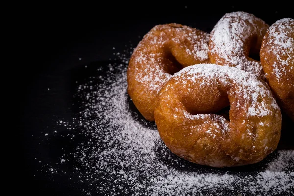 Sprinkling sugar powder on donut