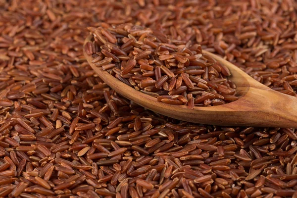 Red rice in a wooden spoon