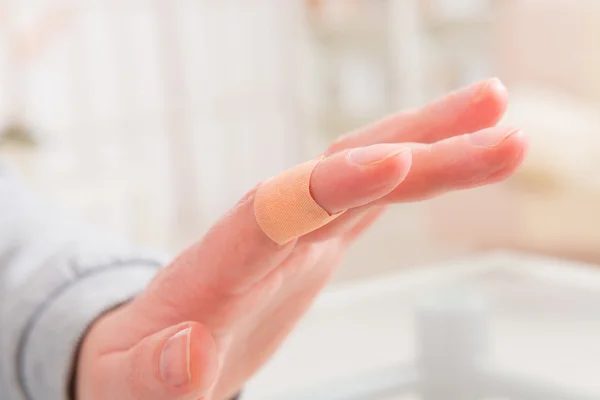 Applying adhesive bandage on finger