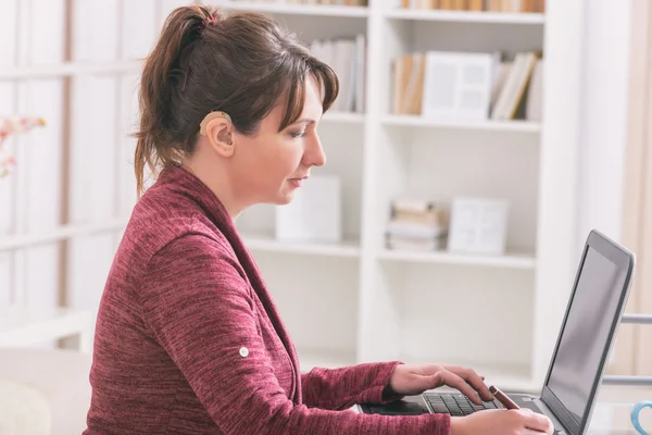 Hearing impaired woman working with laptop