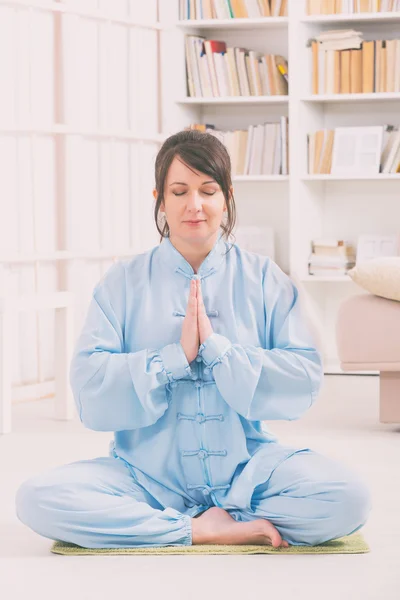 Meditating woman at home