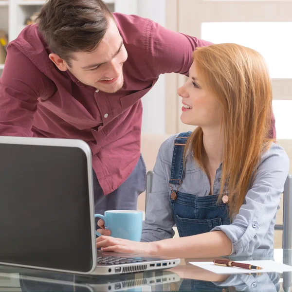 Happy couple at home with laptop computer