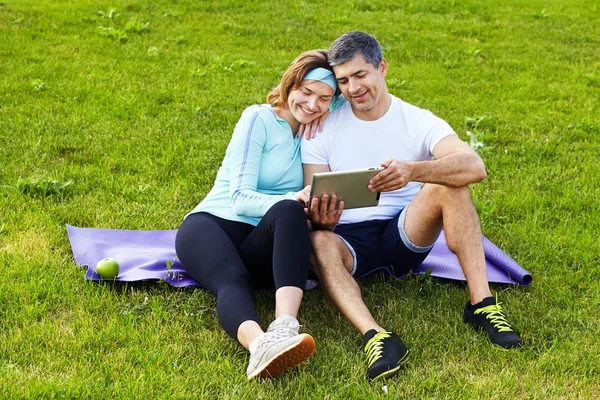 Sports couple using digital tablet