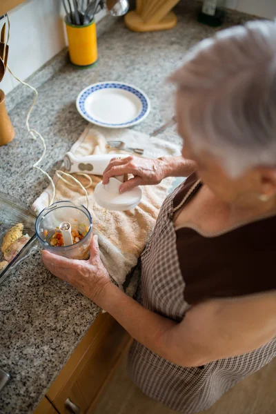 Elderly woman cooking in the kitchen