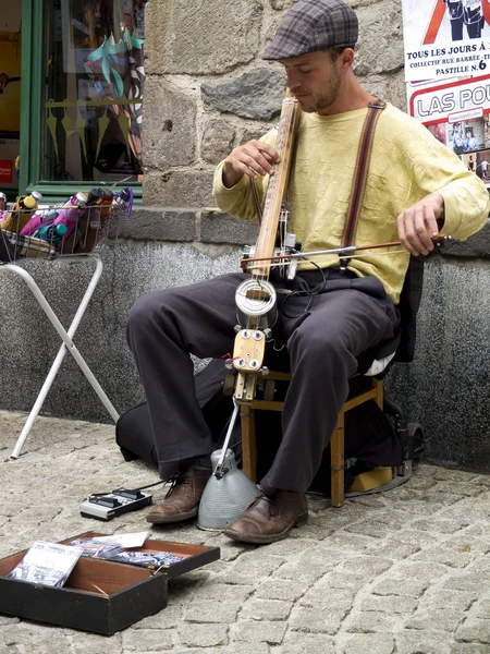 Anonymous street musician playing stringed instrument.