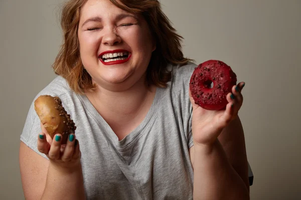 Happy woman holding donuts