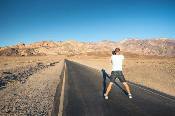 Young man taking pictures in Death Valley, California, USA.