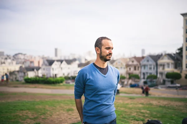 Handsome and bearded man standing on The Painted Ladies of San F