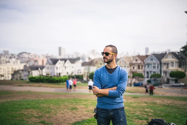 Handsome and bearded man standing on The Painted Ladies of San Francisco