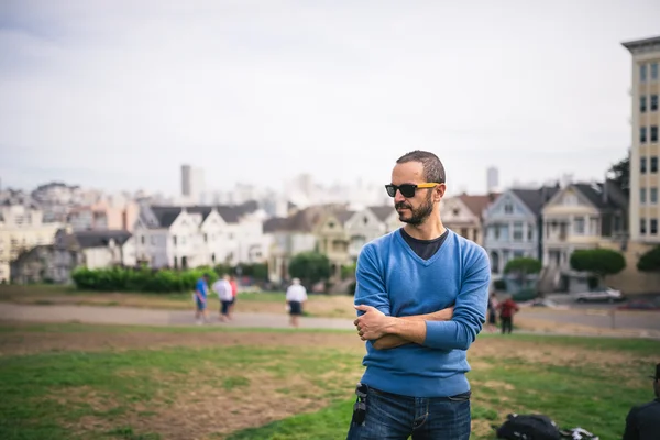 Handsome and bearded man standing on The Painted Ladies of San F