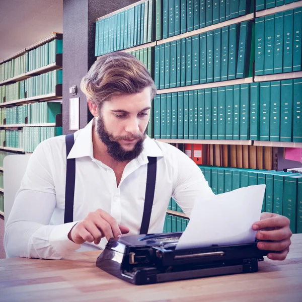 Hipster using typewriter at desk